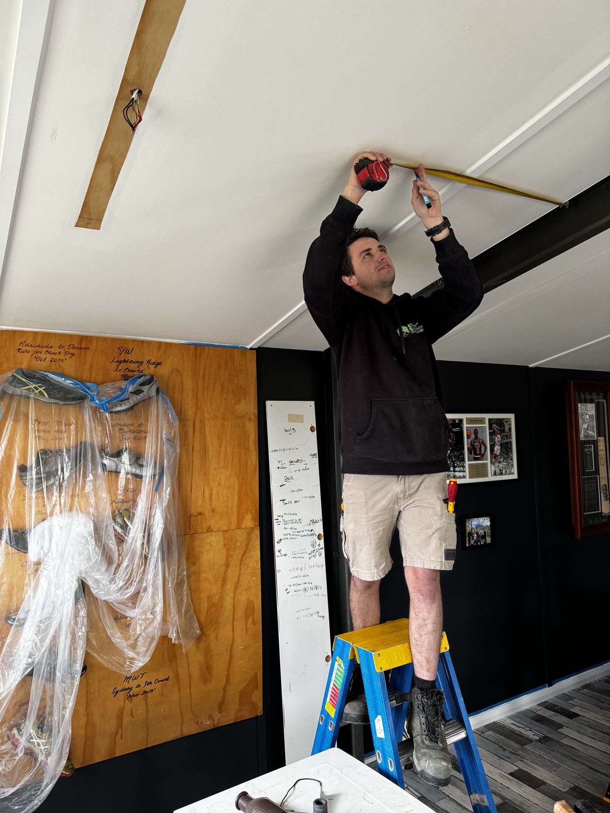 Expert Electrical Services electrician installing a ceiling light