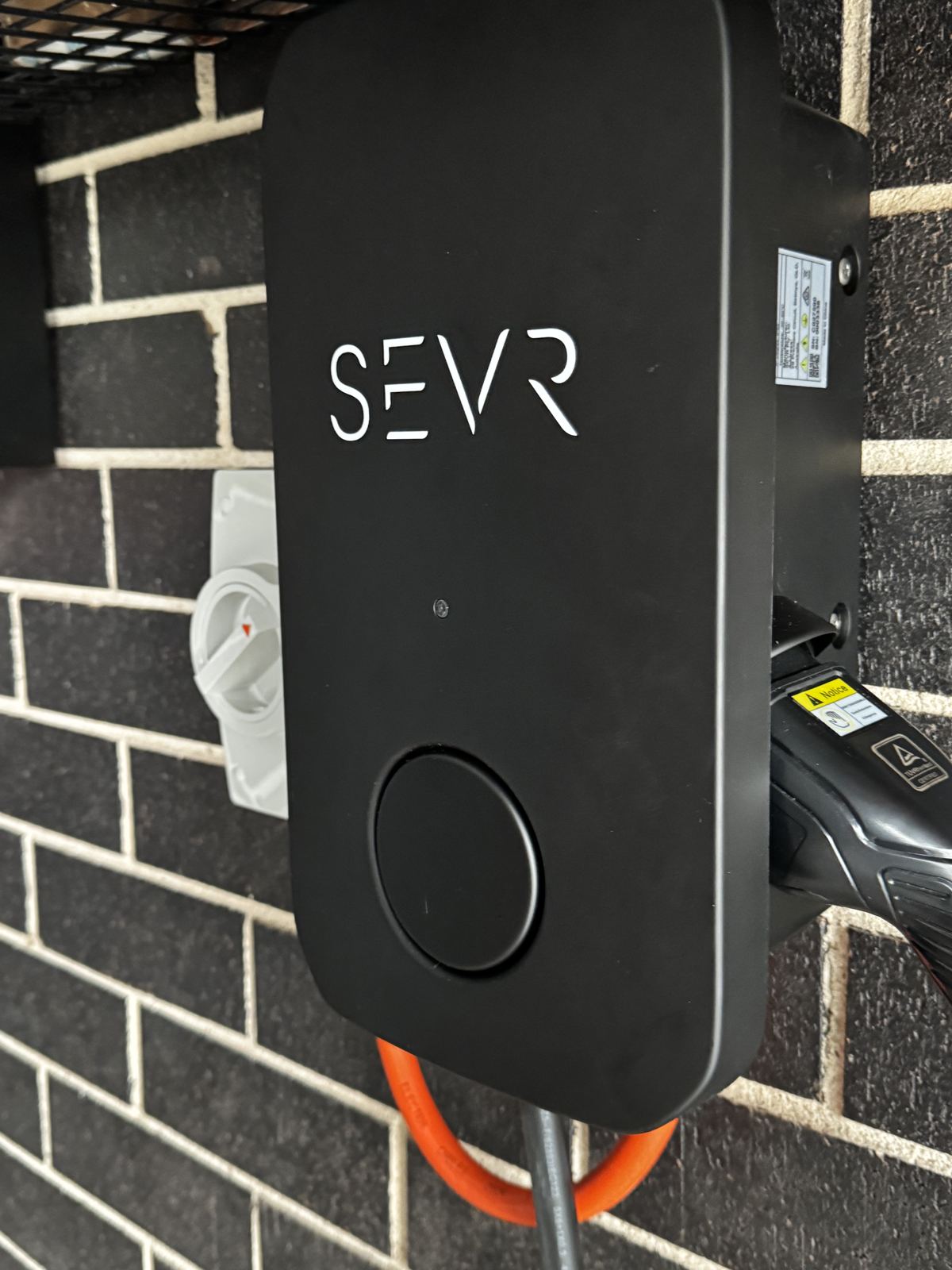 Close-up of a home EV charger installed in a garage