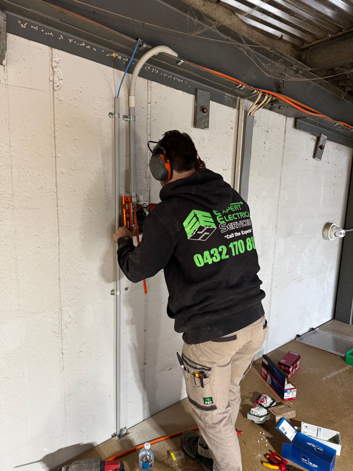 Expert Electrical Services electrician running new wiring on a building site