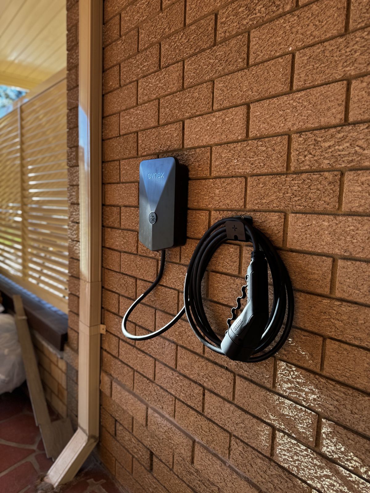 Evnex EV charger installed on a brick wall