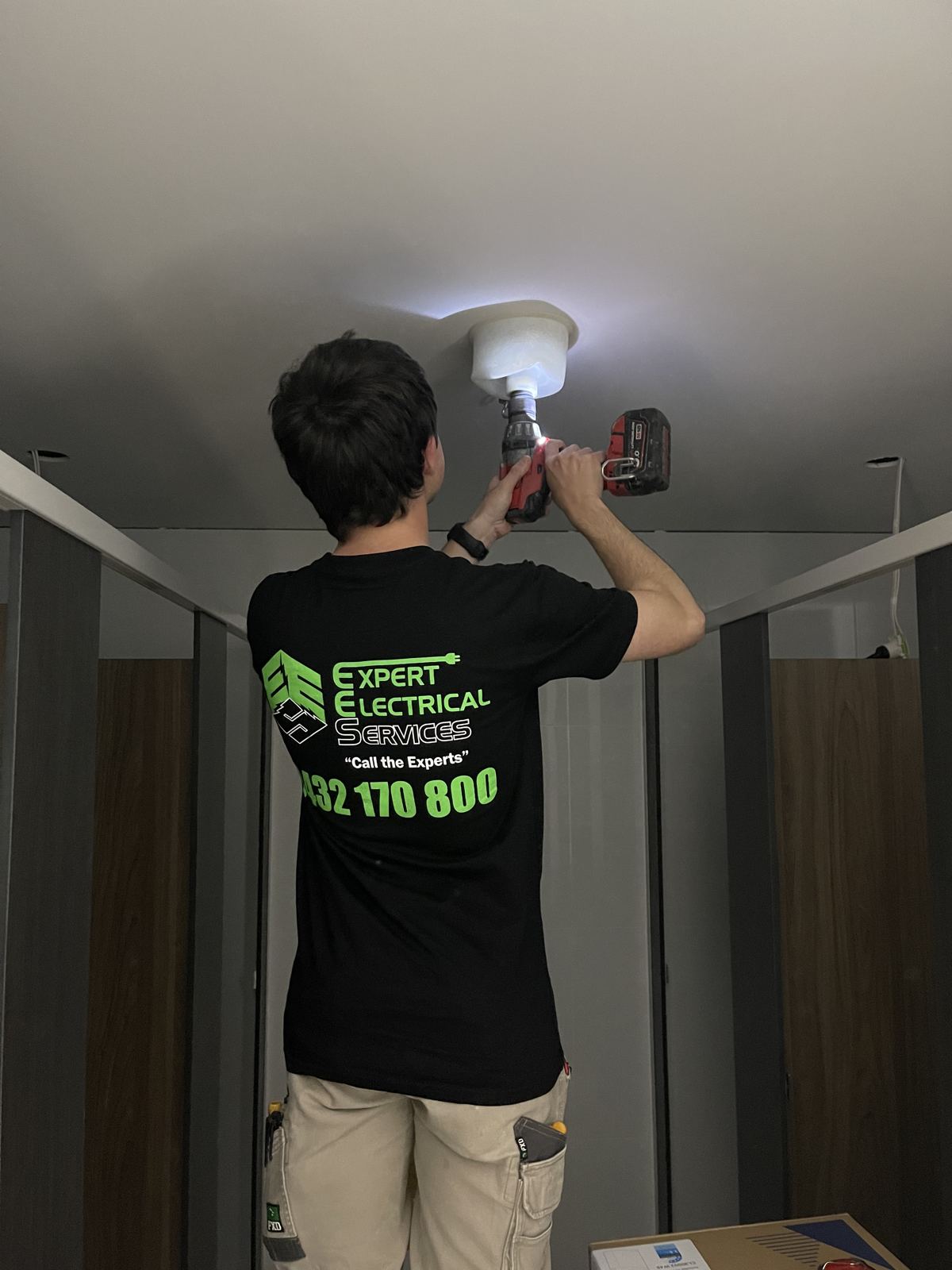 Expert Electrical Services electrician working on a ceiling fitting