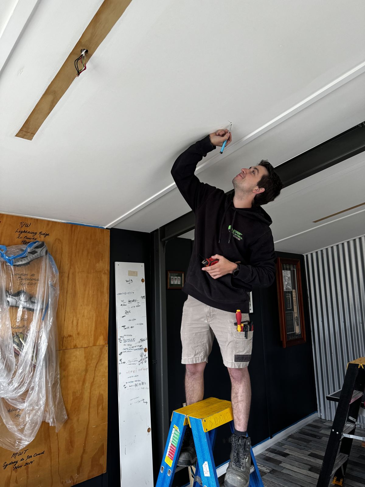 Expert Electrical Services electrician installing a light