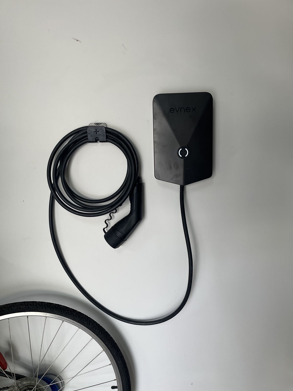 Wall-mounted EV charger with tethered cable
